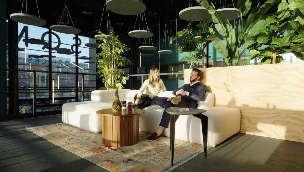 Twee adviseurs in gesprek in een lichte lounge met planten en designmeubilair